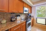 Granite countertops, custom cabinetry, and ocean views make preparing meals a pleasure