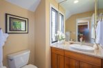 Just off the living room, the guest bathroom includes a tiled walk-in shower, updated vanity, and granite countertops