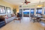 Bathed in natural light, the living room is a welcoming retreat, where panoramic sliding glass doors open to the endless blues of the Pacific and beyond