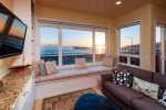 Living room features a window alcove and comfy seating to soak in the coastline