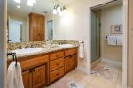 Primary bathroom with dual vanity and step in shower