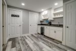 Lower level Kitchenette with beverage refrigerator, sink, and countertop