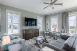 Cozy living room with flat screen TV, queen sleeper sofa, and balcony access.