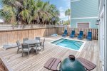Outside pool deck, grill, and lounge area.