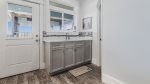 The quaint sink and 1/2 bathroom area just inside from the pool there`s a fridge` here as well