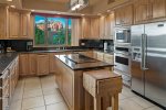 The fully-equipped kitchen features modern stainless appliances and amenities 