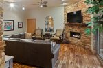 A cozy space with large leather sofas, flat screen TV and fireplace