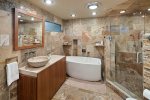 Guests enjoy a custom bathroom with a walk-in shower and soaking tub