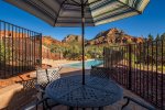 Fenced pool area with shaded outdoor table 