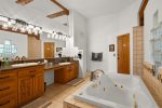 Private ensuite bathroom with deep jetted tub and dual vanities