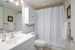 Bright master bathroom has a tub/shower combo.
