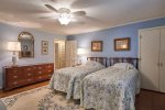 Th twin bedroom has dressers, closets, rugs, and comfortable bedding.