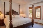 The master bedroom has a beautiful King four poster bed and a view of the ponds.