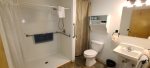Spacious bathroom with roll in shower and wheel chair accessible sink.