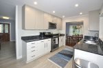 Kitchen with wood grain flooring & recessed ceiling lighting.