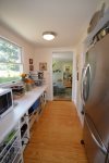 Open pantry way to kitchen from sun room, stainless steel fridge 