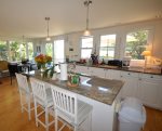 Large kitchen with seating at island, views onto deck and marsh