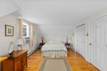 Bright third bedroom upstairs featuring a queen bed and relaxing natural light.