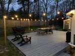 The space is illuminated by string lights that surround the deck