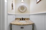 Stylish half bathroom with coastal themed decor 