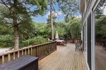 Spacious deck with an outdoor dining table, umbrella, and grill