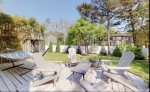 Lower level deck in the backyard with adirondack chairs and a hammock