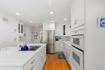 Bright white kitchen with a large stainless steel refrigerator