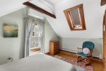 The room features vaulted ceilings and a skylight, perfect for a light-filled and comfortable stay in your Harwich rental