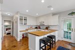 Two stools at the eat-in kitchen counter create a casual space to enjoy morning coffee or chat with the chef