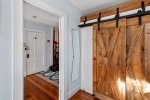 The sliding barn-door closet adds character and coastal charm to this inviting Provincetown bedroom.