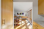 Dining room flows from the kitchen with a large table and sunlit windows, ideal for Wellfleet gatherings.