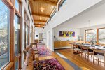 Sunlit hallway with tall windows and warm wood ceiling details, a signature mid century modern Cape Cod look.
