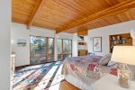 Primary bedroom with king bed, beamed ceiling, and oversized windows, quiet Wellfleet comfort for restful nights.