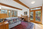 Sunny guest bedroom with outdoor access and vintage desk, classic Wellfleet charm with mid century modern ease.