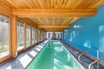 Indoor lap pool with entry rail, skylit feel, and wide windows, perfect for morning laps and rainy day relaxation