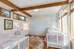 Twin bedroom with playful wallpaper and two beds, kid friendly sleeping space in Wellfleet, Cape Cod.