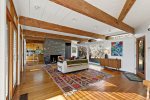 Spacious great room with fireplace wall, wood beams, and natural light, classic mid century modern comfort in Wellfleet.