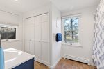Full bathroom with tub shower and wide storage closet, easy routines after beach days in Eastham.
