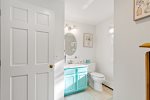 Full bathroom with aqua vanity, bright and simple for quick rinses and morning routines on Cape Cod.