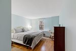 Lower level king bedroom with hardwood floors and soft lighting, quiet space for restful Eastham nights.