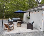 Fire pit patio setup with cushioned seating and cafe lights, perfect for smores and stargazing on Cape Cod.