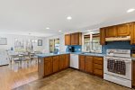 Kitchen with generous counters and open sightlines to dining, easy hosting for summer groups on Cape Cod.
