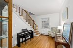 Sunny stair landing with piano and reading chair, extra hangout space for music, puzzles, or quiet time.