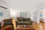 Open living and dining space with mini split AC, hardwood floors, and French doors, comfortable Cape Cod rental