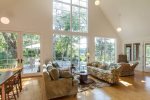 Soaring great room with cathedral ceilings and a wall of windows, where sunlight fills the space and flows effortlessly to the deck with stunning marsh views.