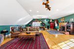 Sunlit bonus game room with a pool table, fireplace, and lounge seating, ideal for group-friendly Cape Cod vacation rentals.