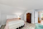 Second upstairs bedroom with a queen bed, dresser, and soft lighting, a quiet place to recharge.