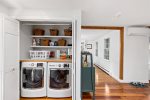 Laundry closet with washer and dryer, supplies, and pet bowls, ideal for longer Cape Cod vacation stays.
