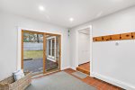 Tiled mudroom entryway with sliders to the deck, hooks and storage for beach bags, towels, and sandy shoes.