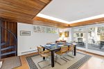 Dining room view with spiral staircase detail and large sliders opening to deck seating for indoor and outdoor meals.